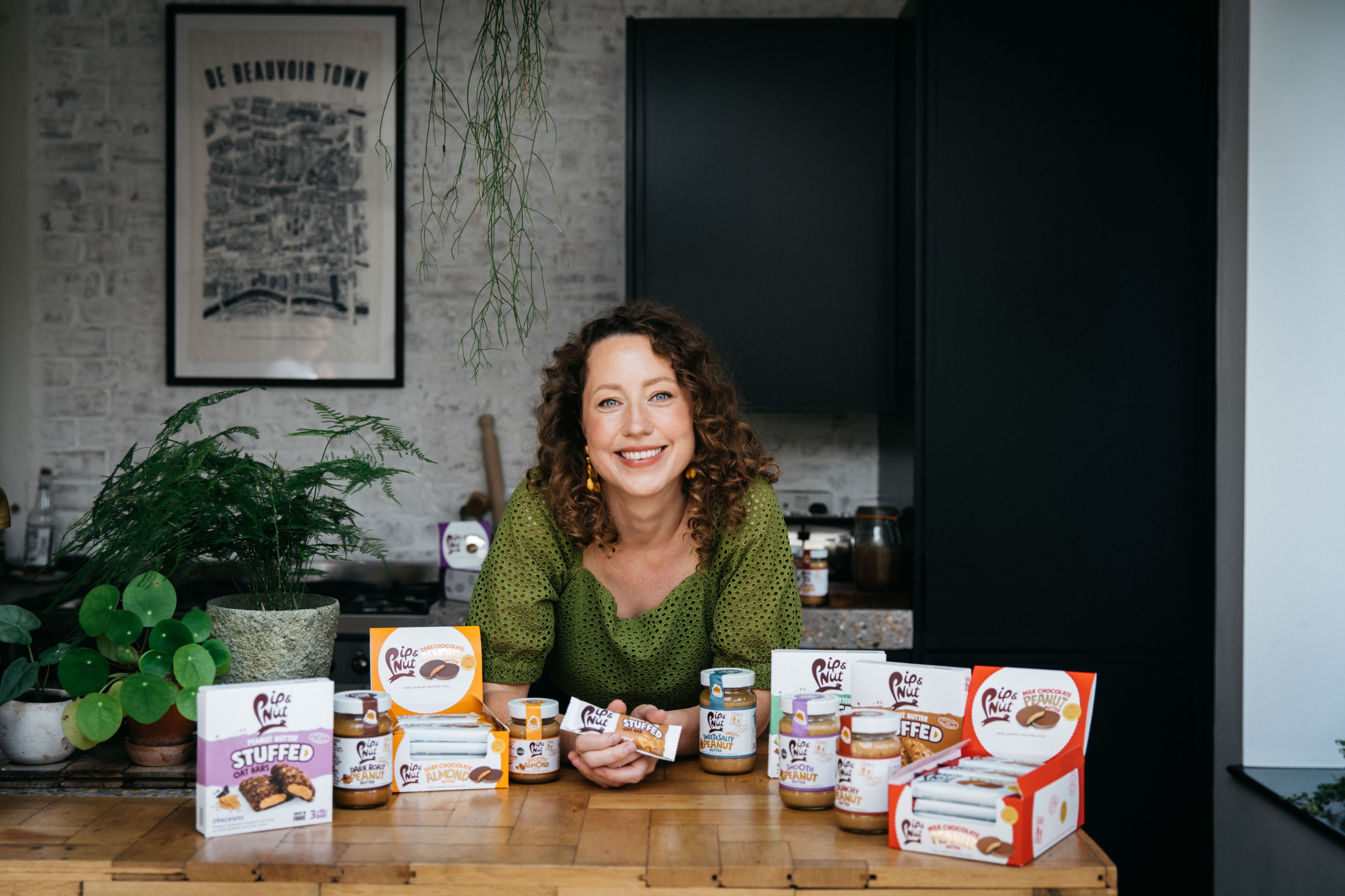 Pip Murray, founder and CEO of Pip & Nut surrounded by product range.