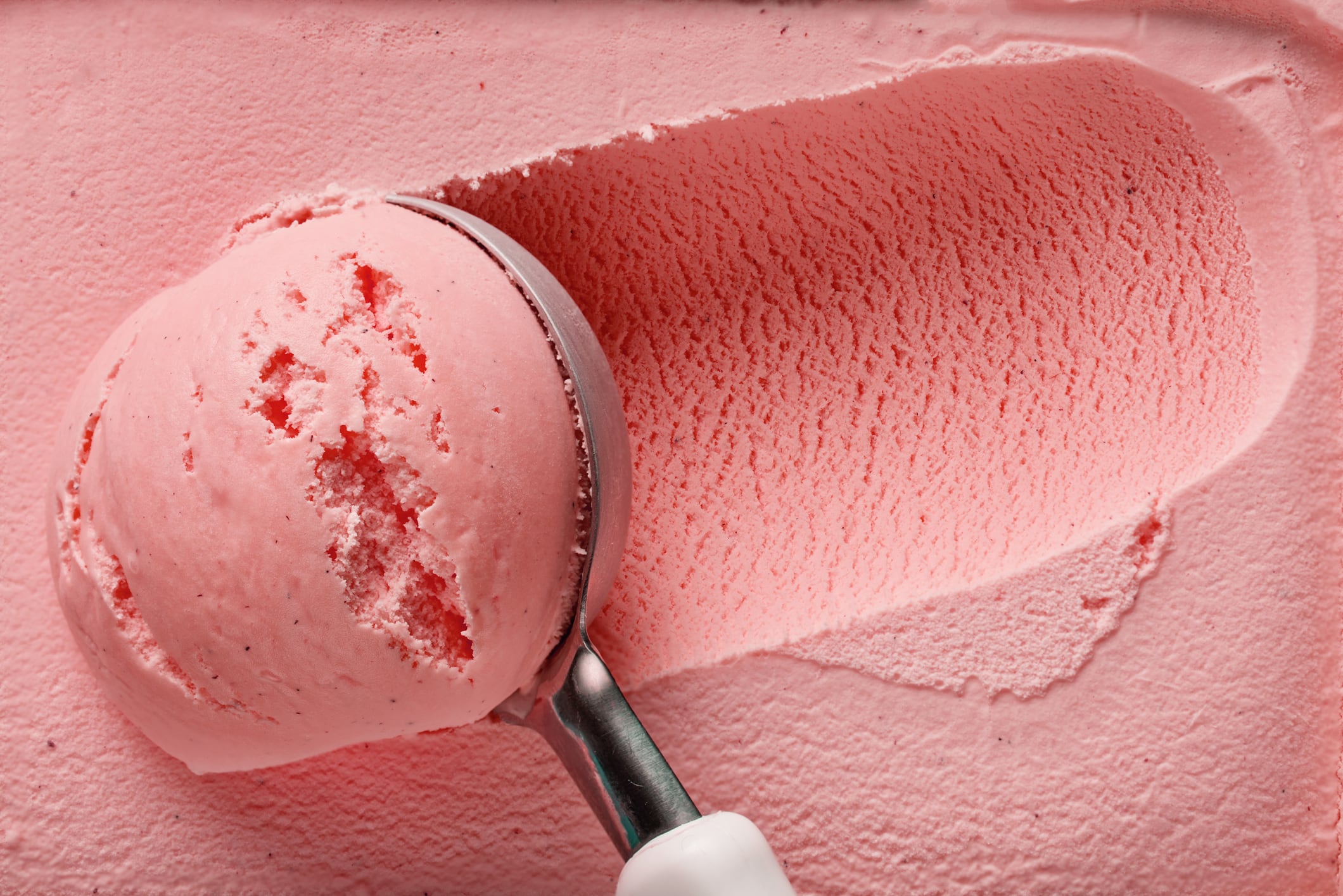 Pink strawberry ice cream ball being scooped