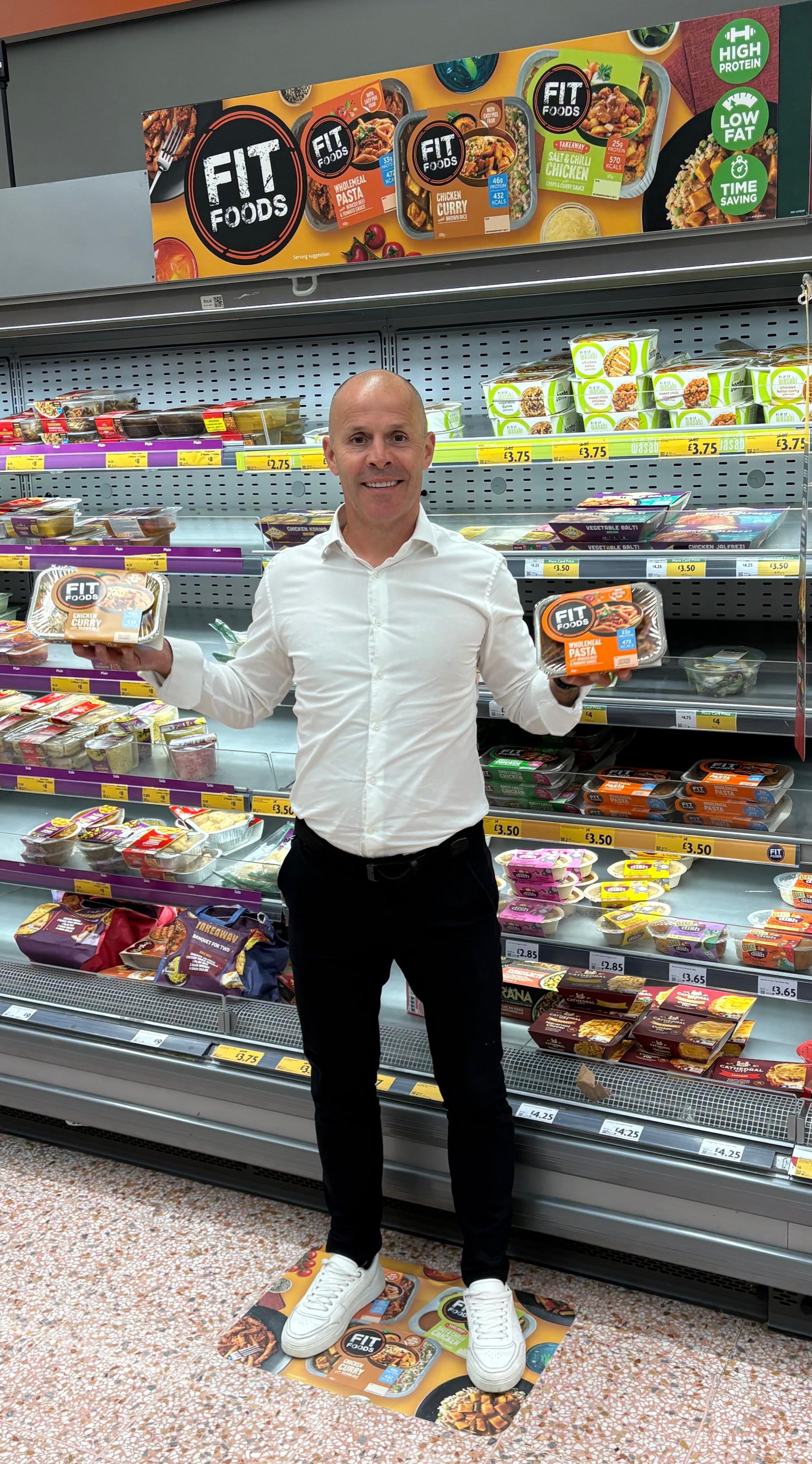 A man holding up products in supermarket