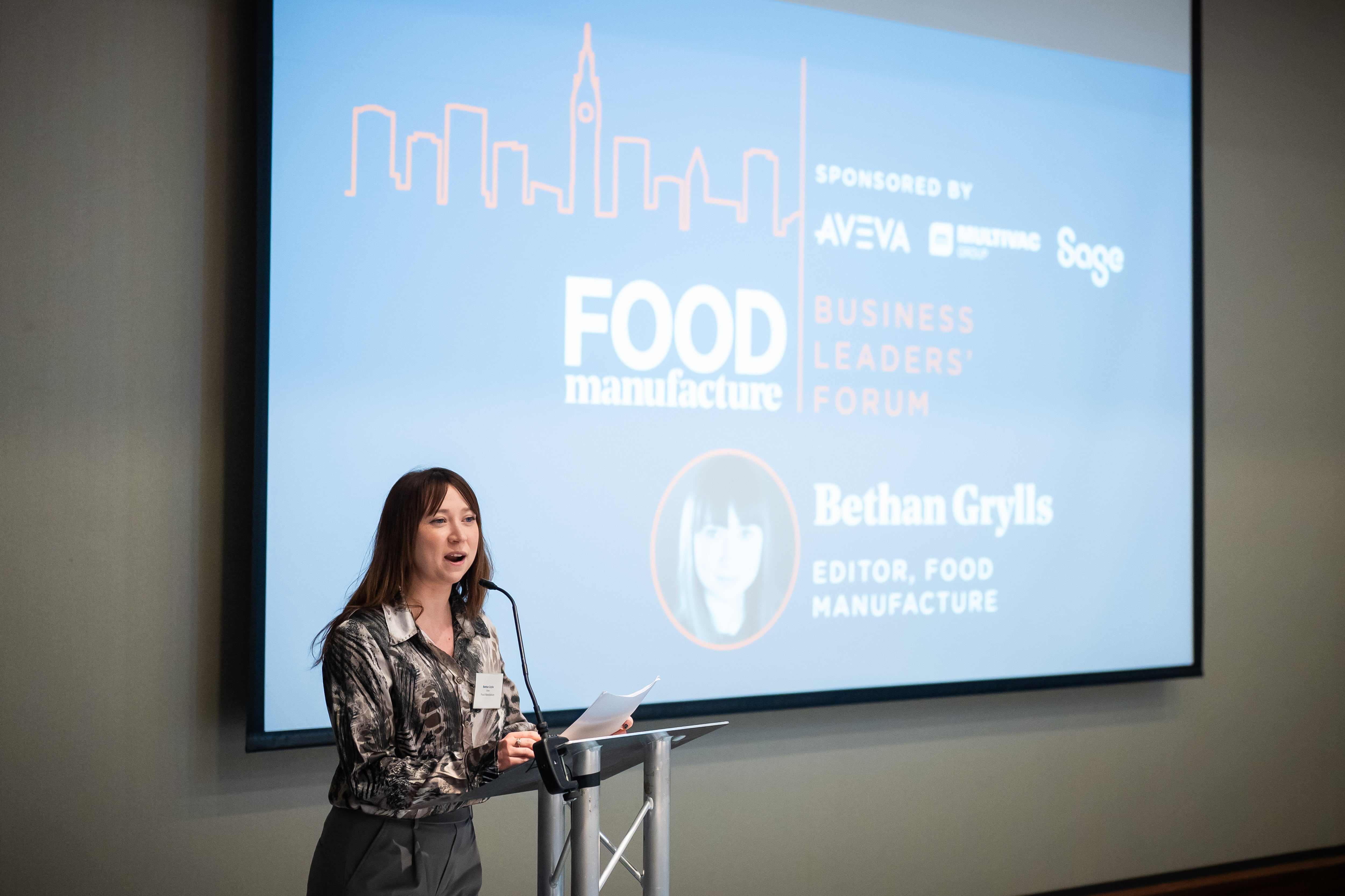 Bethan Grylls speaking in front of a slide at conference.