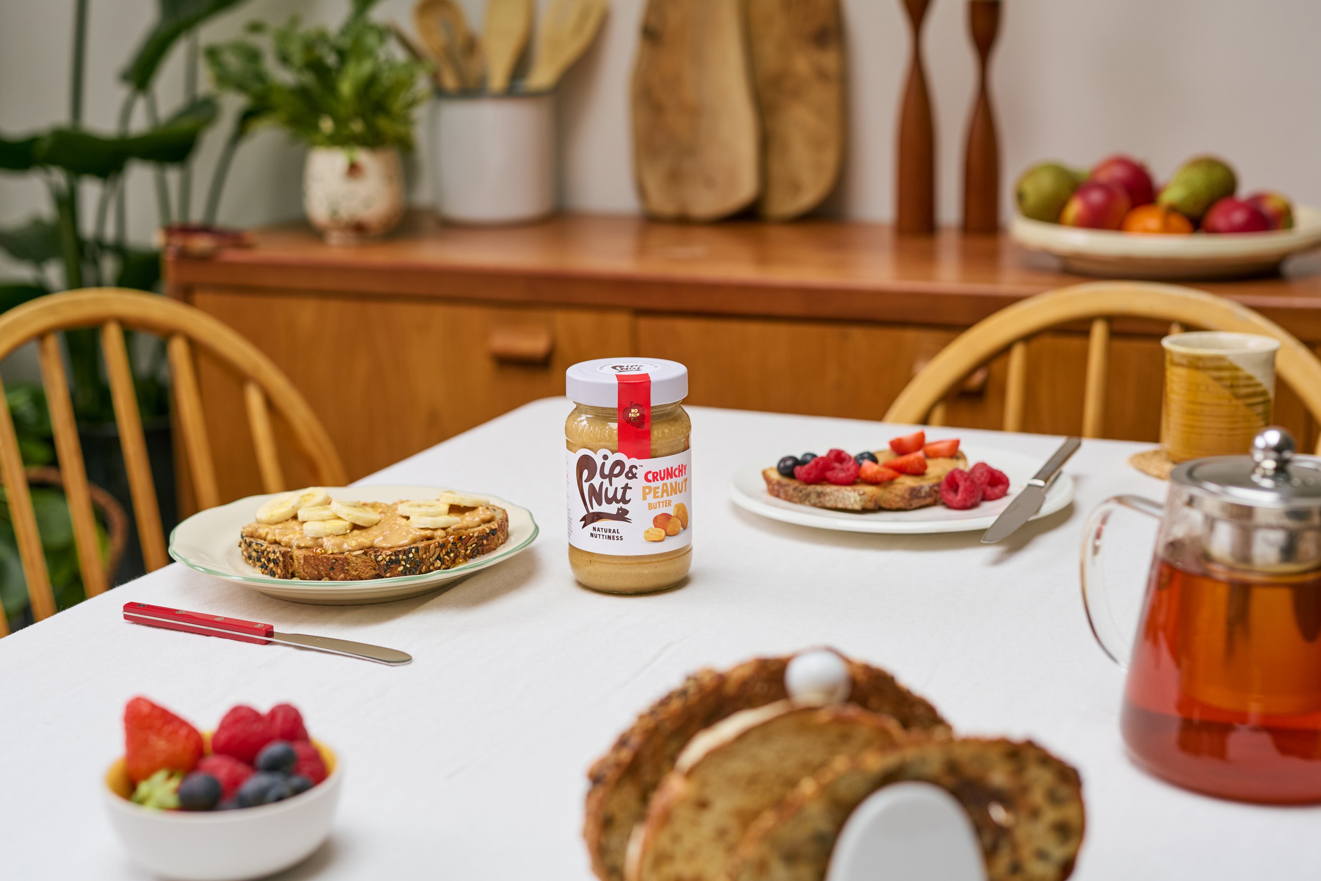 Nut butter with toast and bananas on table.