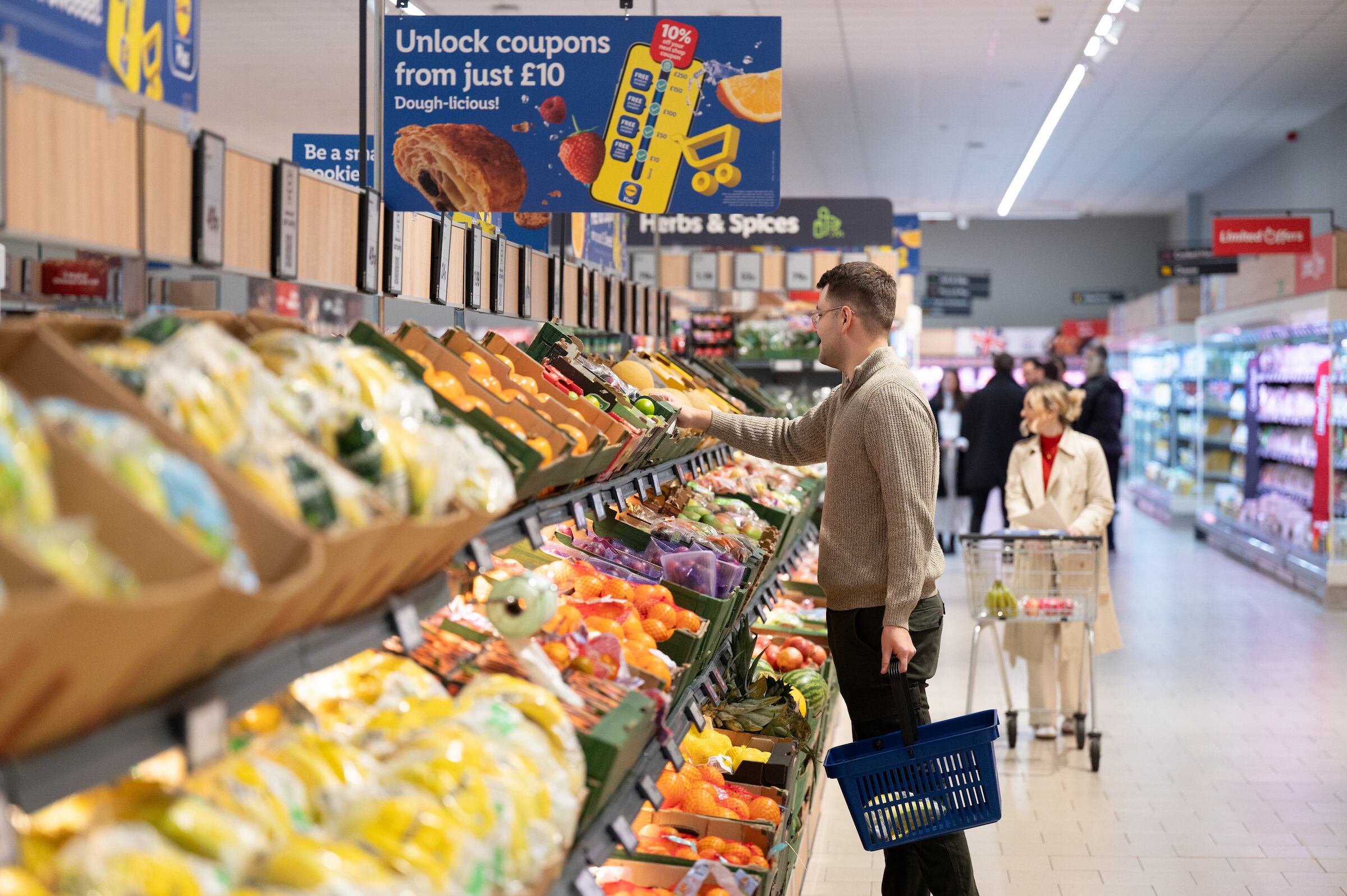 People in supermarket looking at fruit and veg
