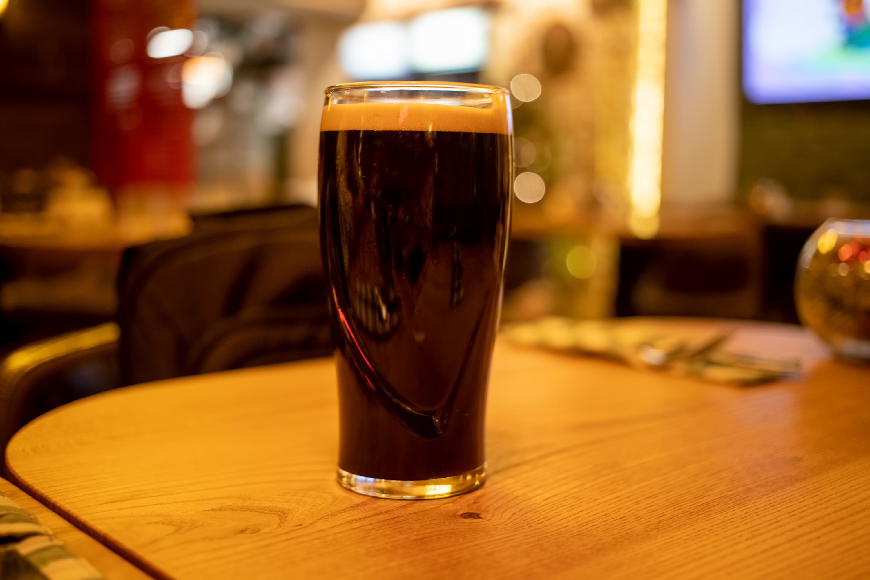 Glass of stout on table.