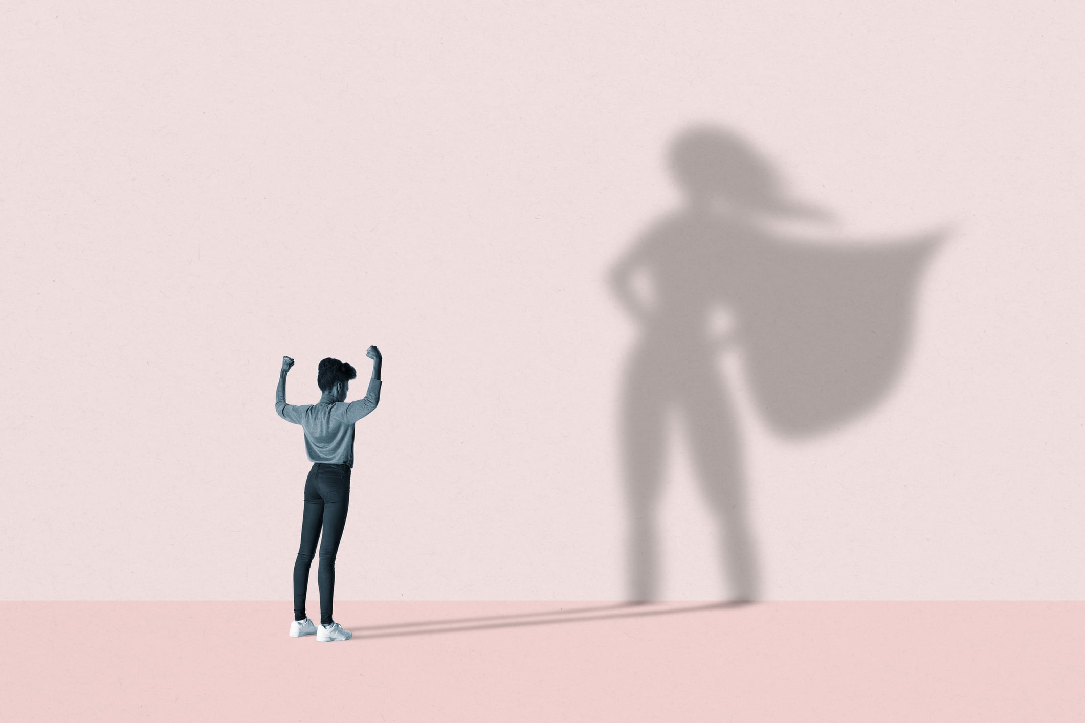 Woman flexing muscles in front of superhero shadow illustrating the women who inspire hospitality leaders