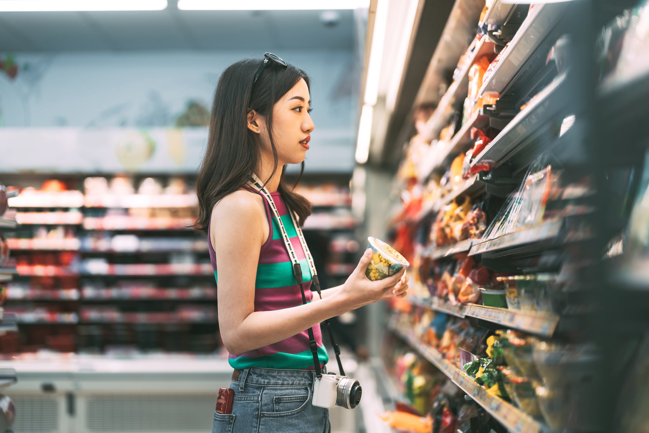 Asian consumer choosing product at supermarket store