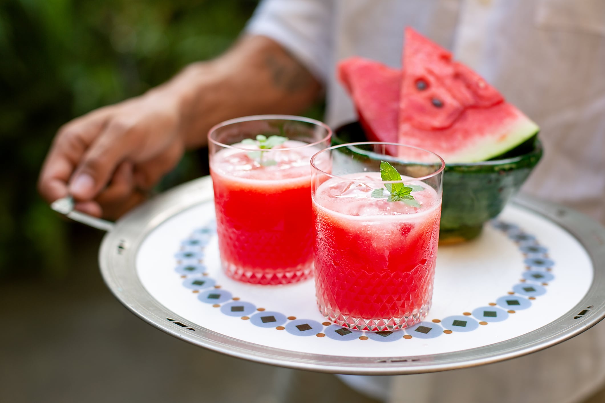 Man holding a tray with fresh watermelon juice
