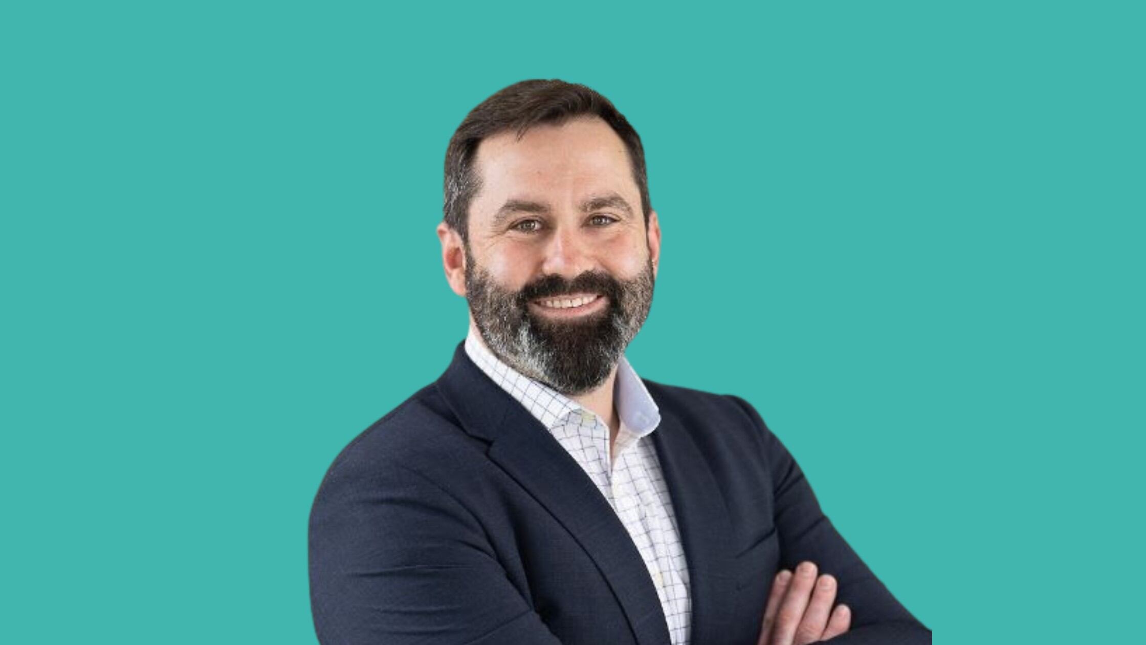 Nick Reade in a suit smiling