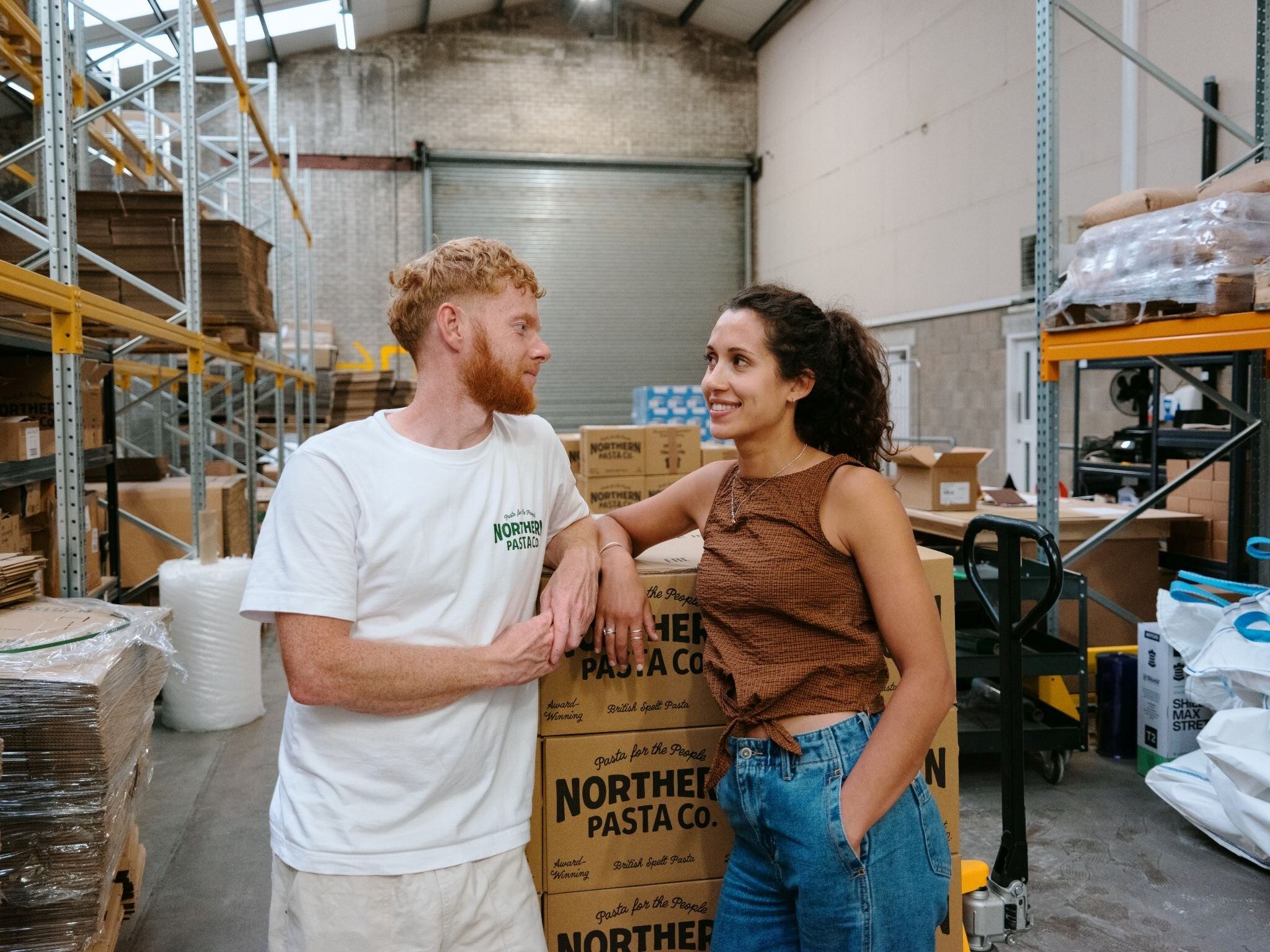 Two people looking at each other in a factory.
