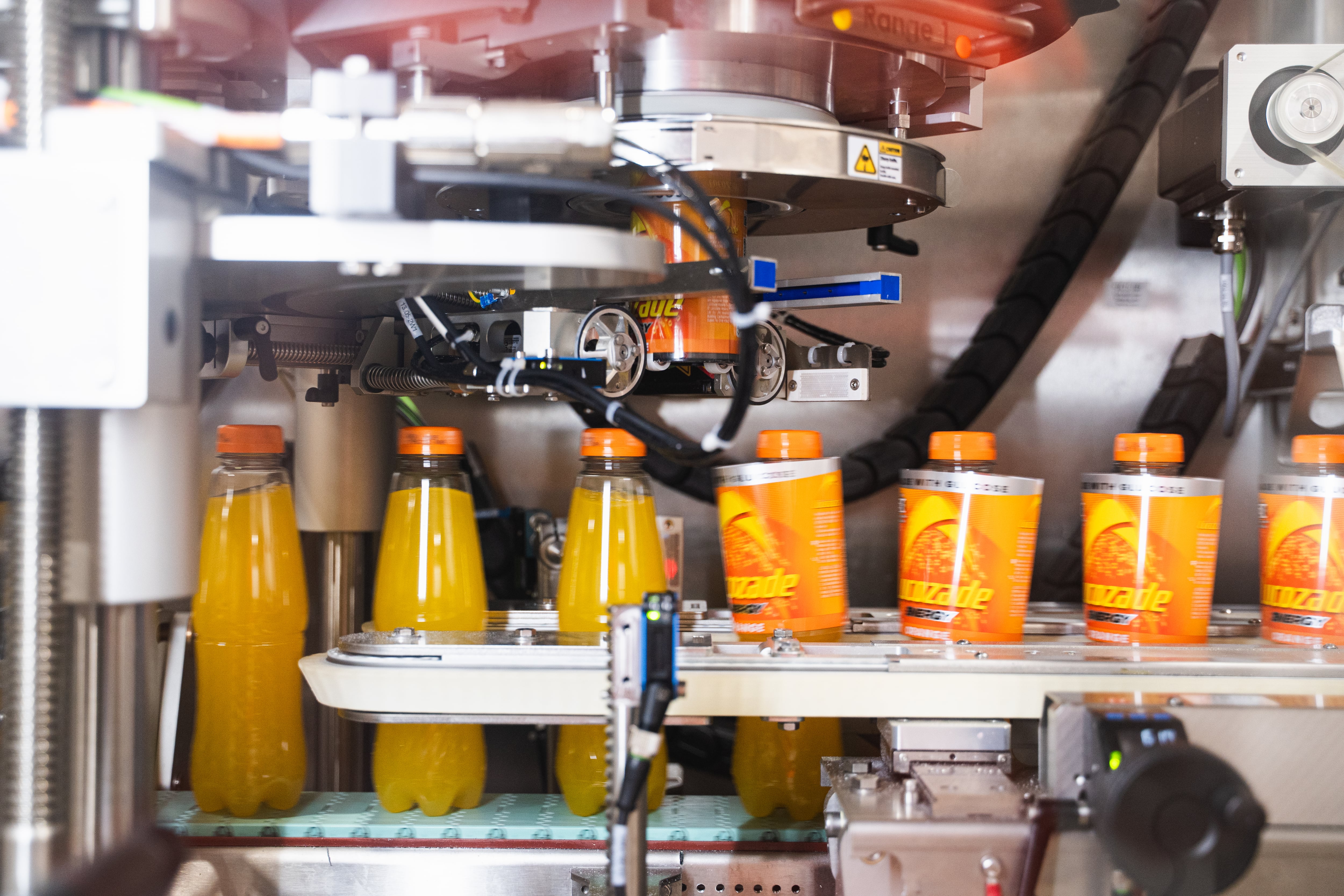 Lucozade sleeves being placed via a machine.