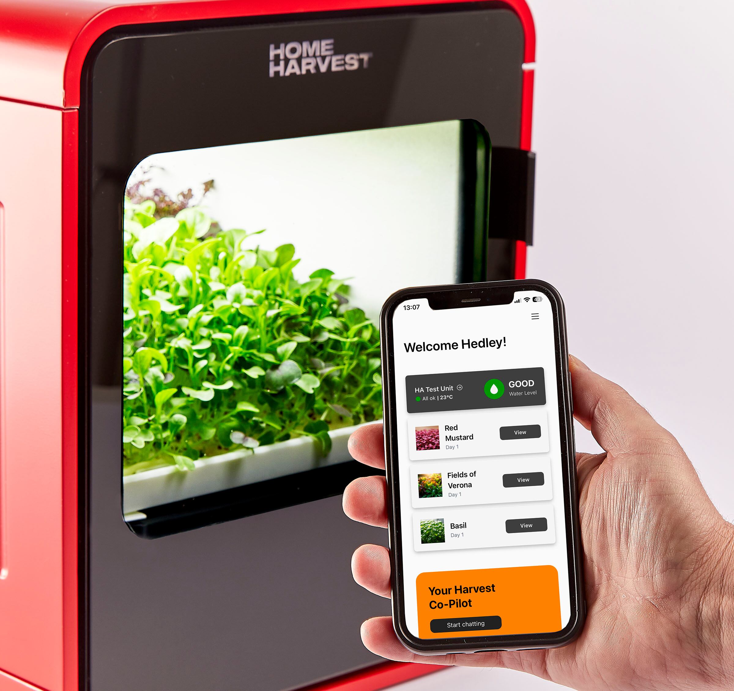 A mobile phone next to a unit growing crops.