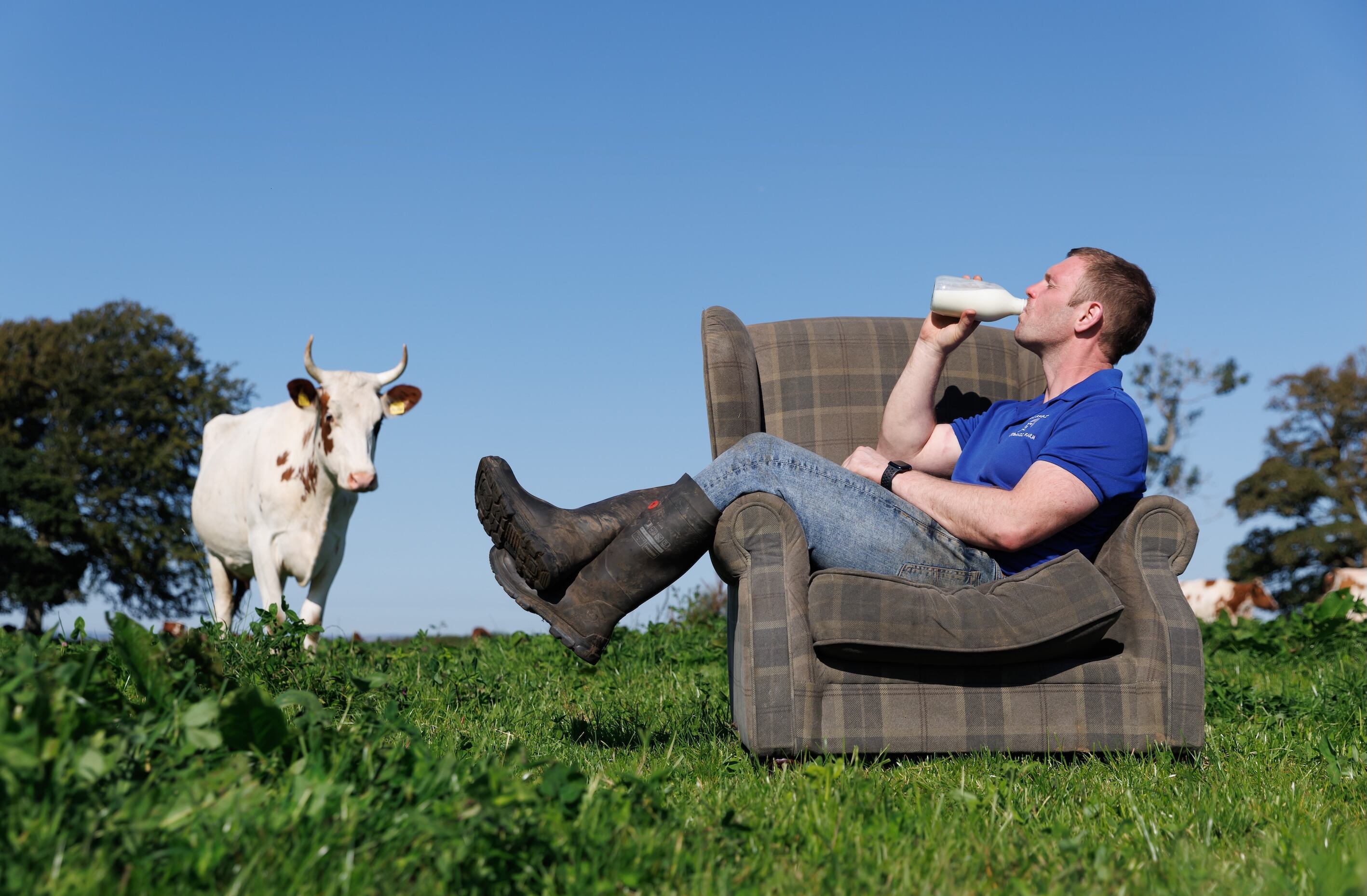 A man in a field drinking milk