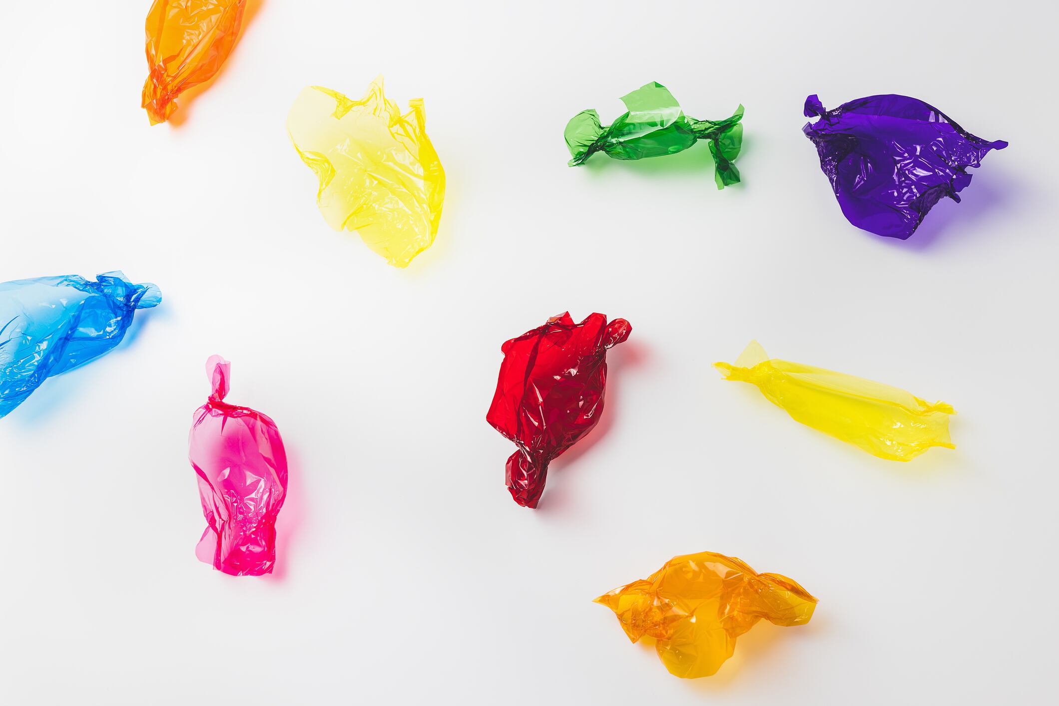 Colourful confectionery wrappers on grey background.