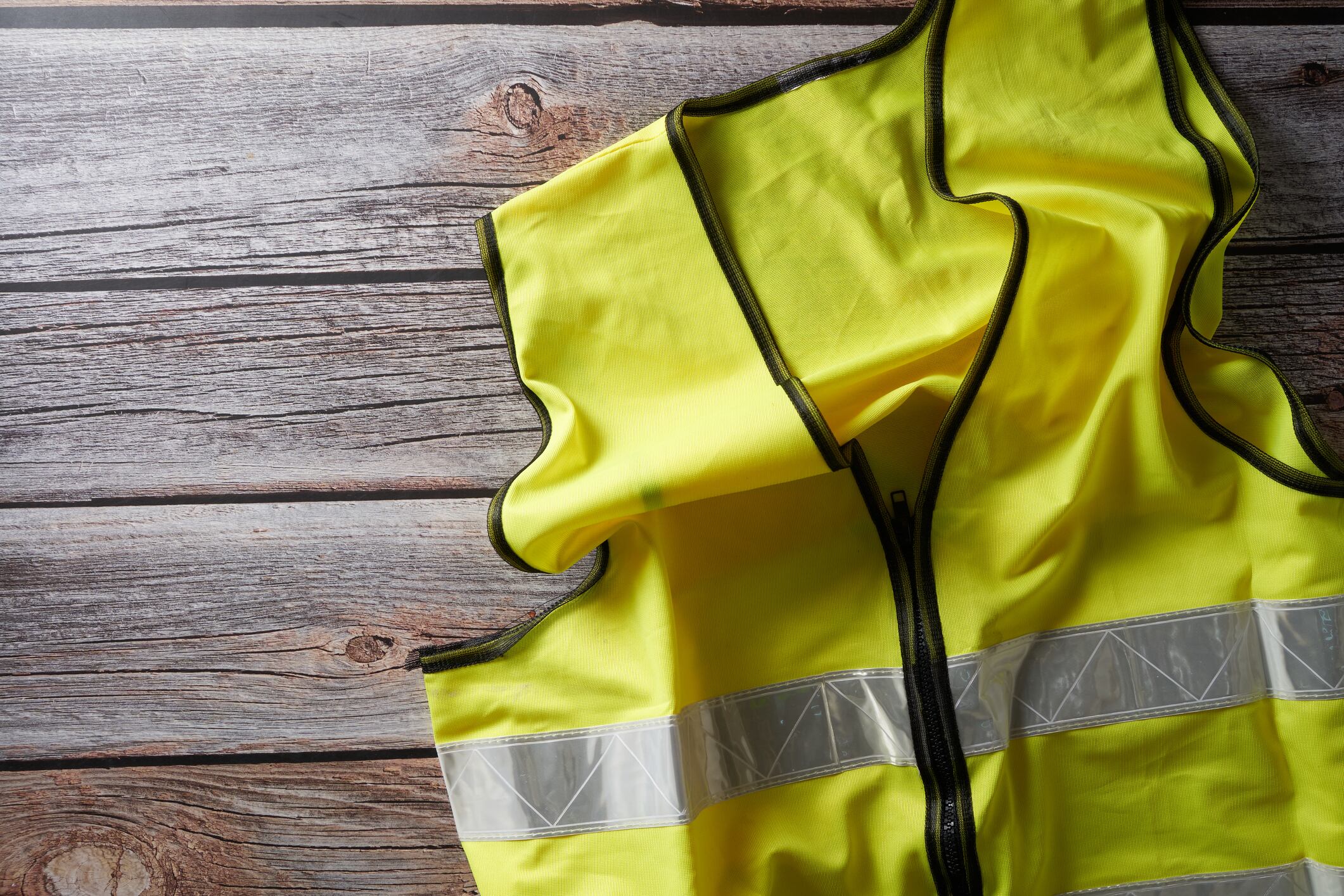 yellow protective waist coat on wood background