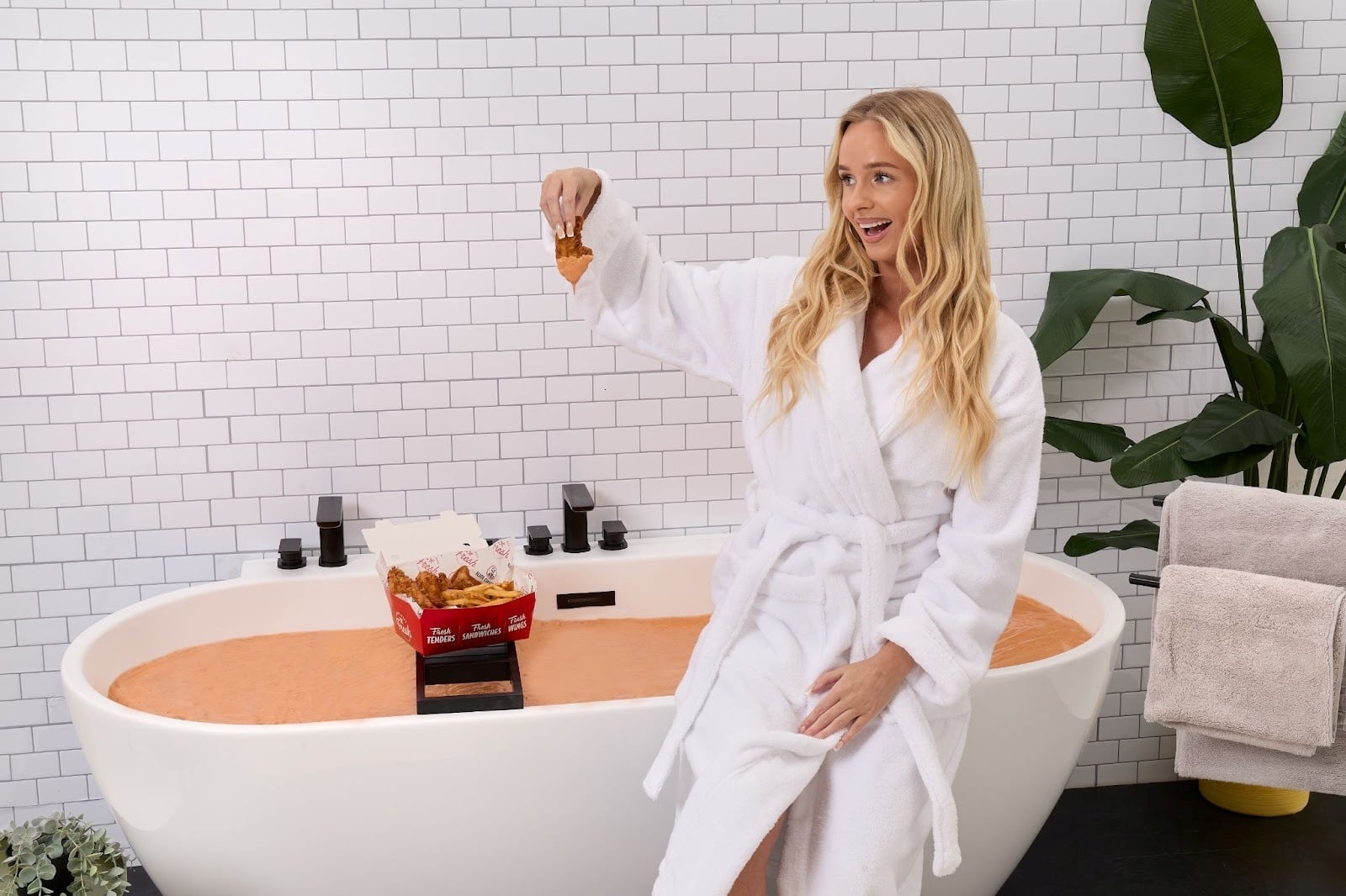 A woman eating chicken on a bath