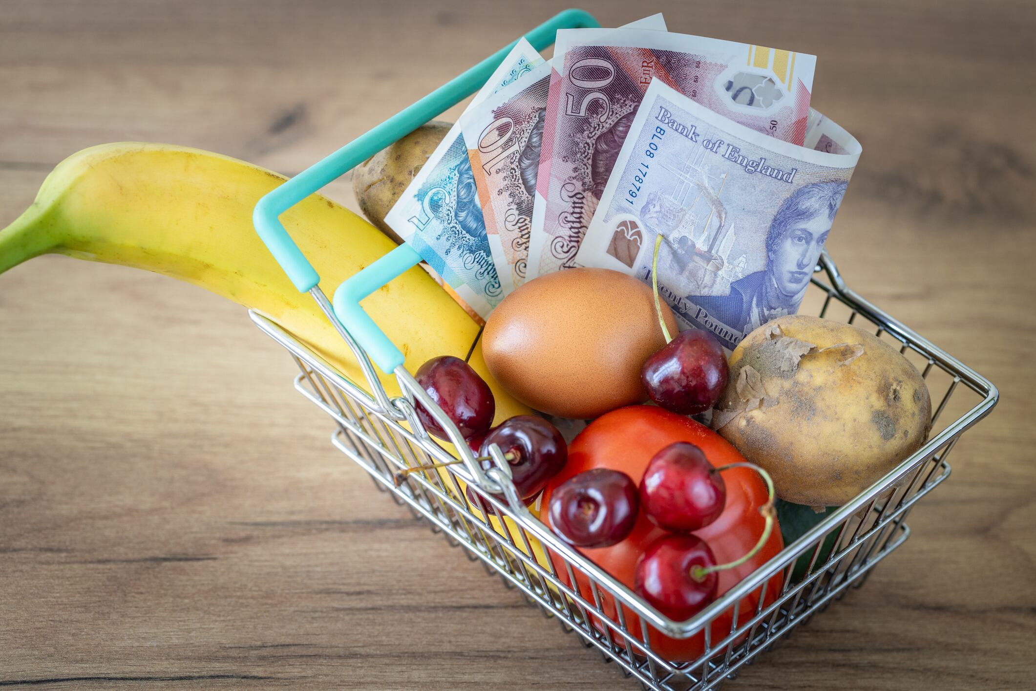 A shopping trolley with GBP bank notes.