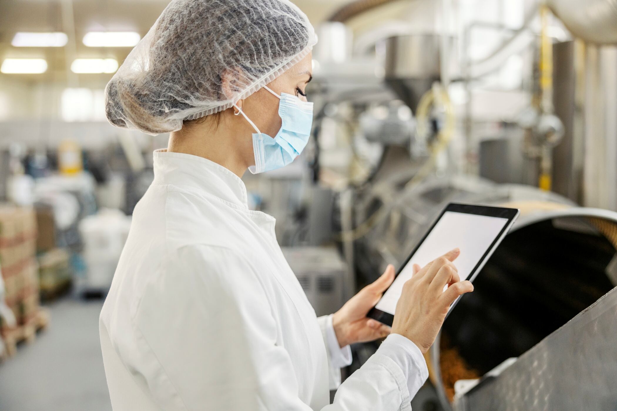 Woman in factory working on a touch screen