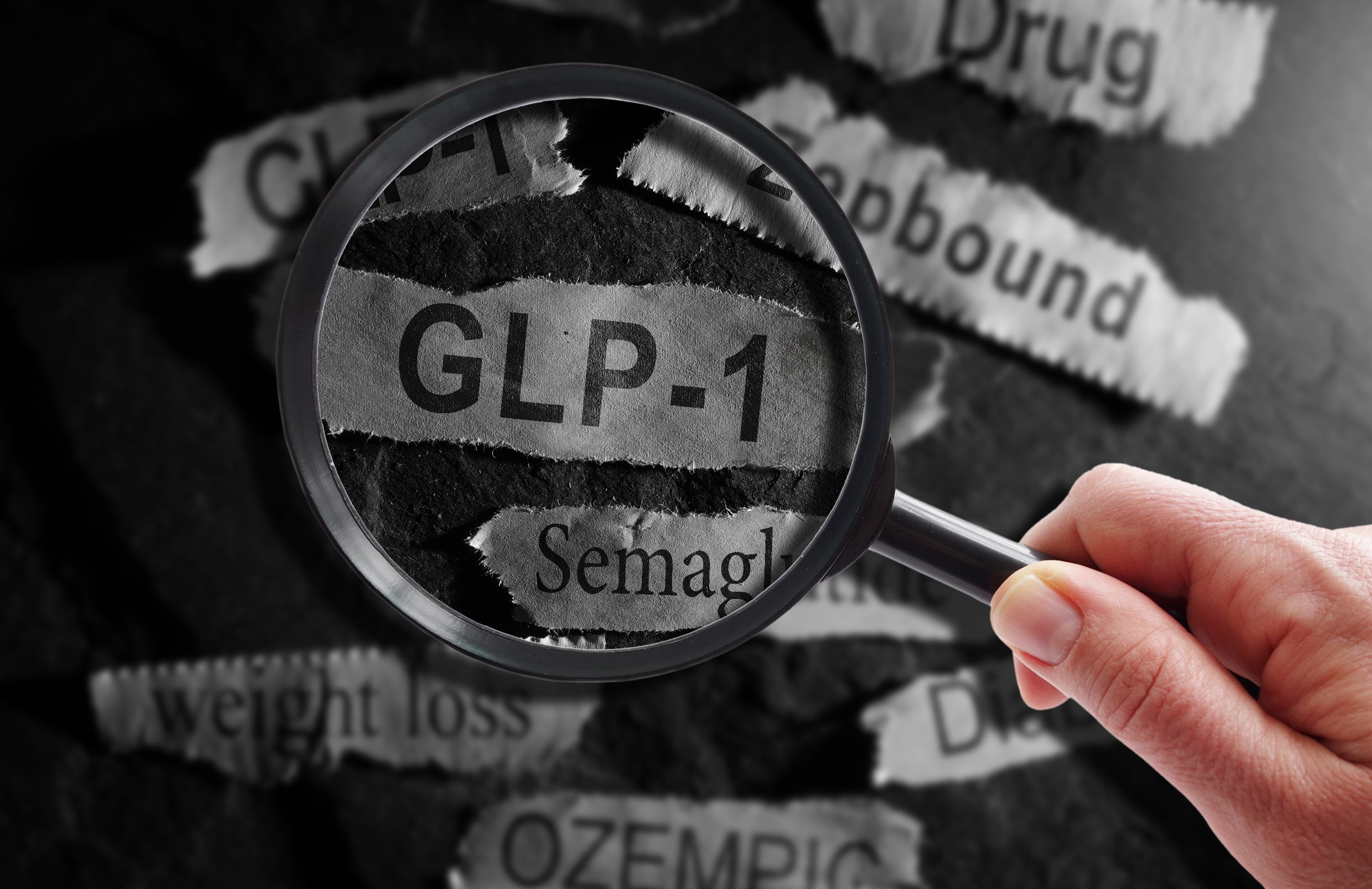 Raleigh, NC - USA - 06-13-2024: GLP-1 related drugs newspaper headlines with hand and magnifying glass