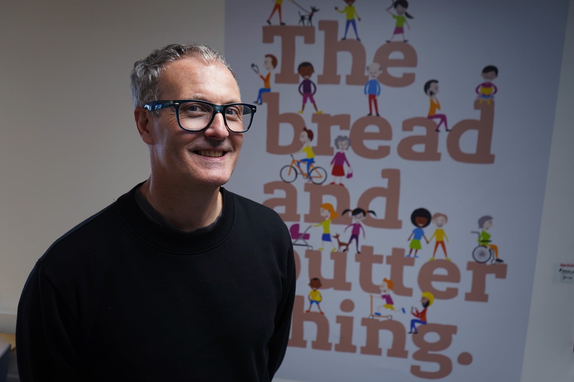 Justin Pritchard standing in front of logo