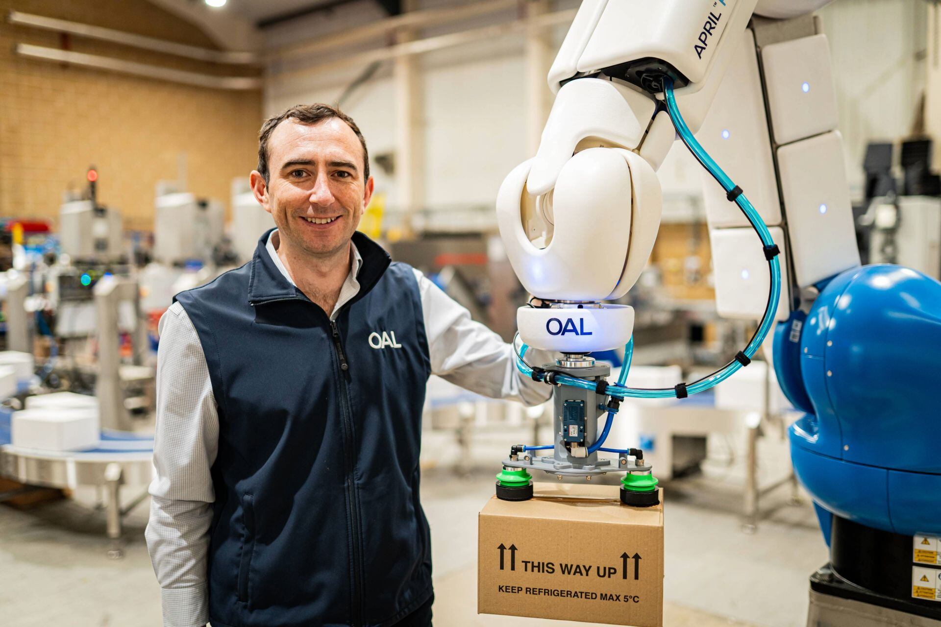 A man posing with a robotic arm.