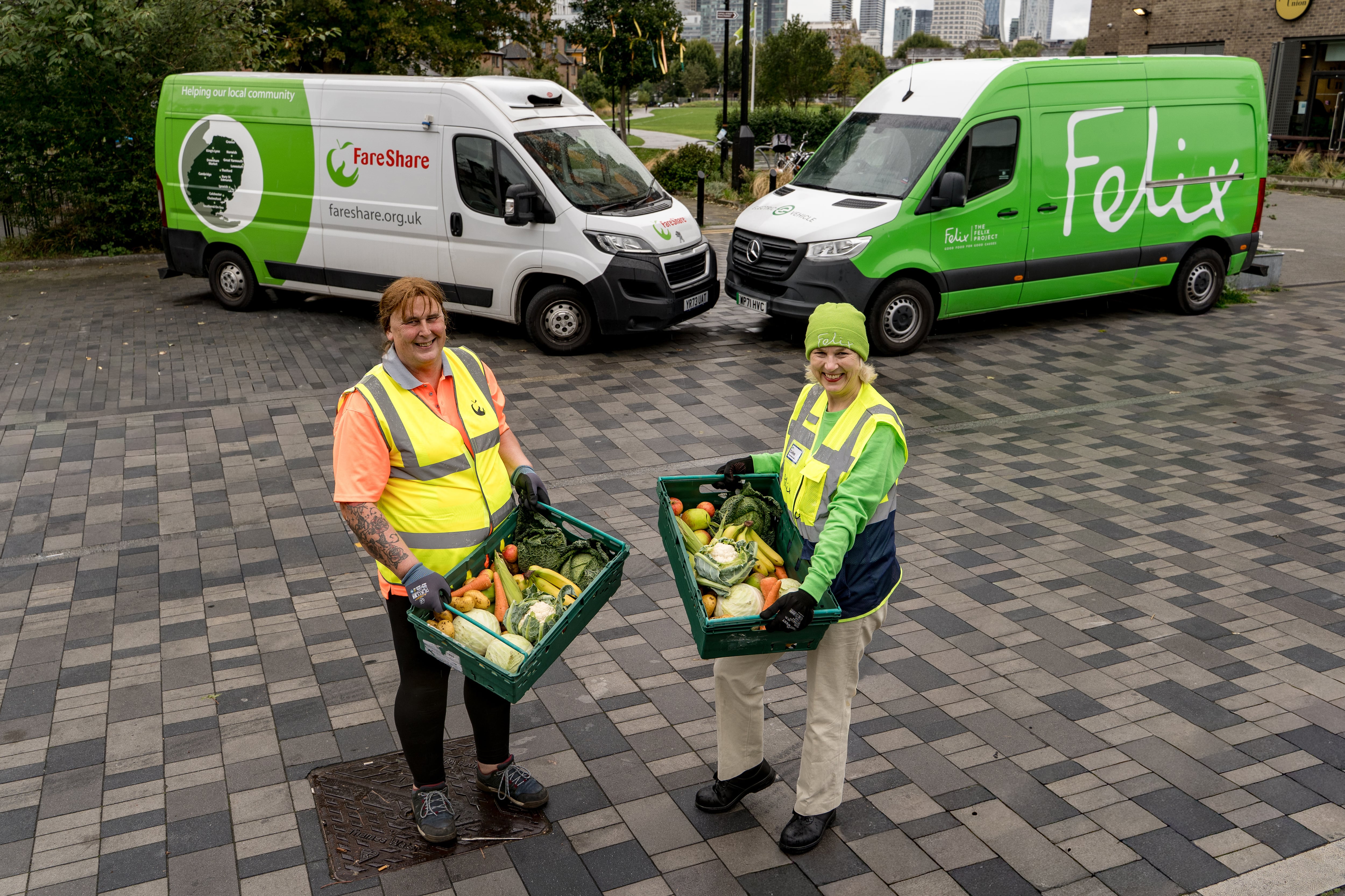Felix and FareShare vans with two people holding food in crates.