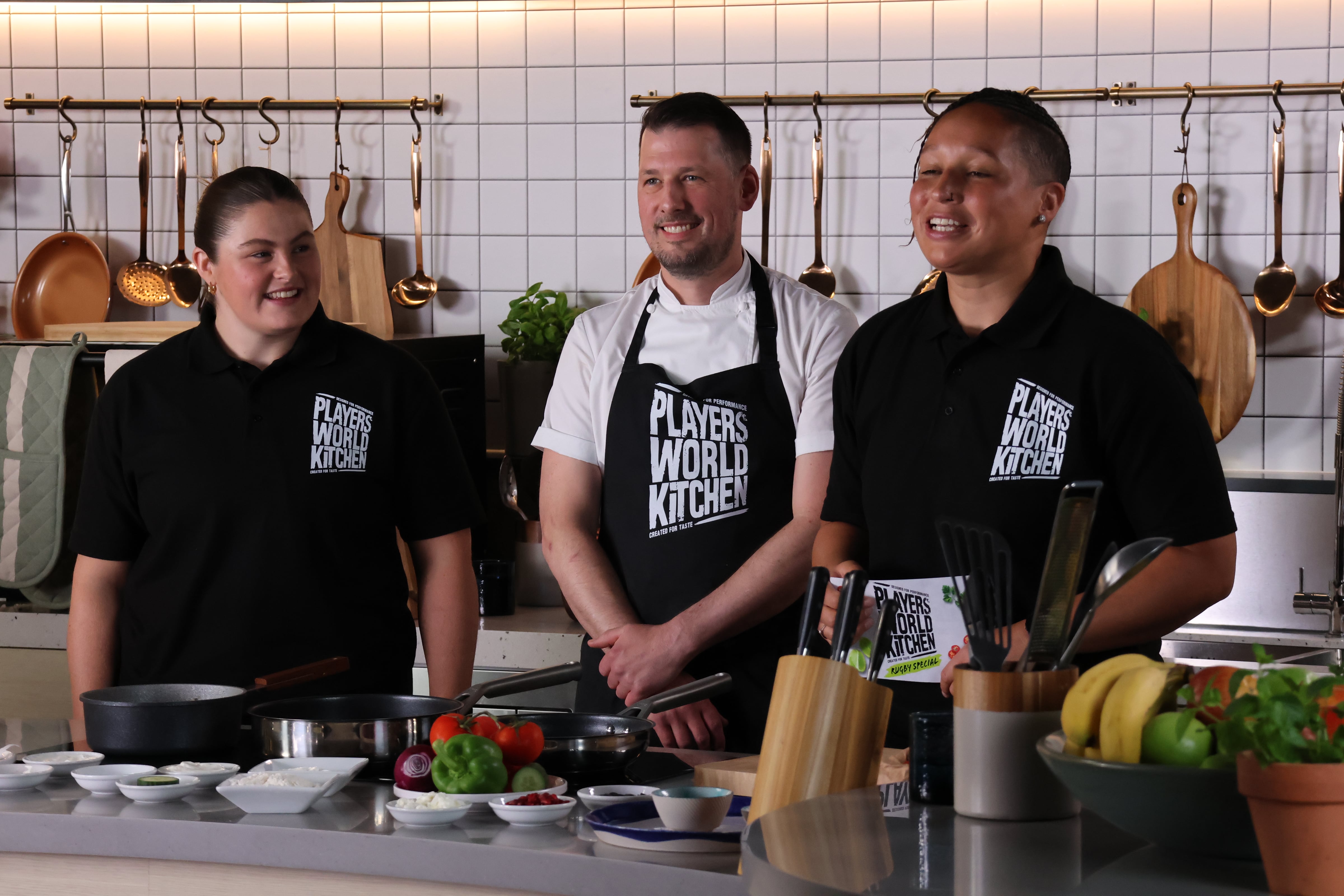 A man and two women in a kitchen TV studio