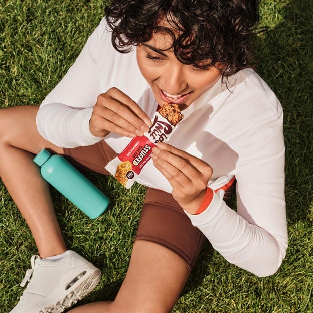 Person eating stuffed oat bar from Pip & Nut.