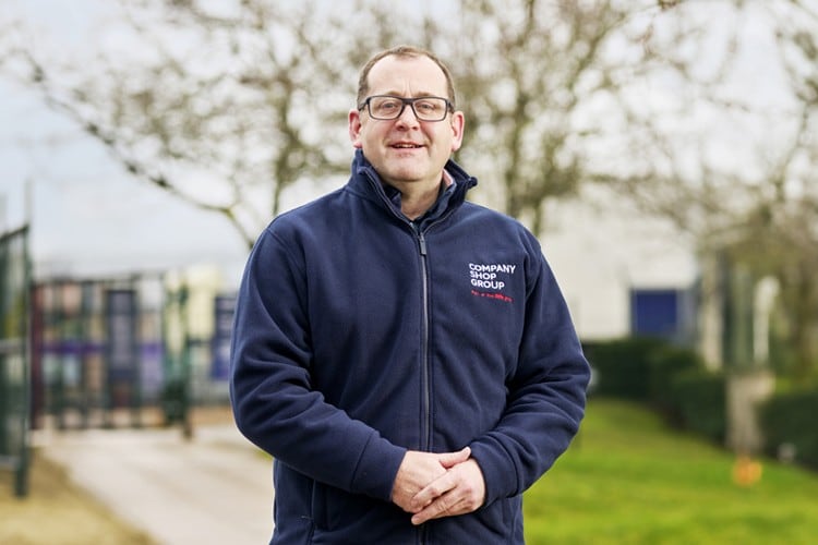 Chris Burns standing outside with his hands folded.
