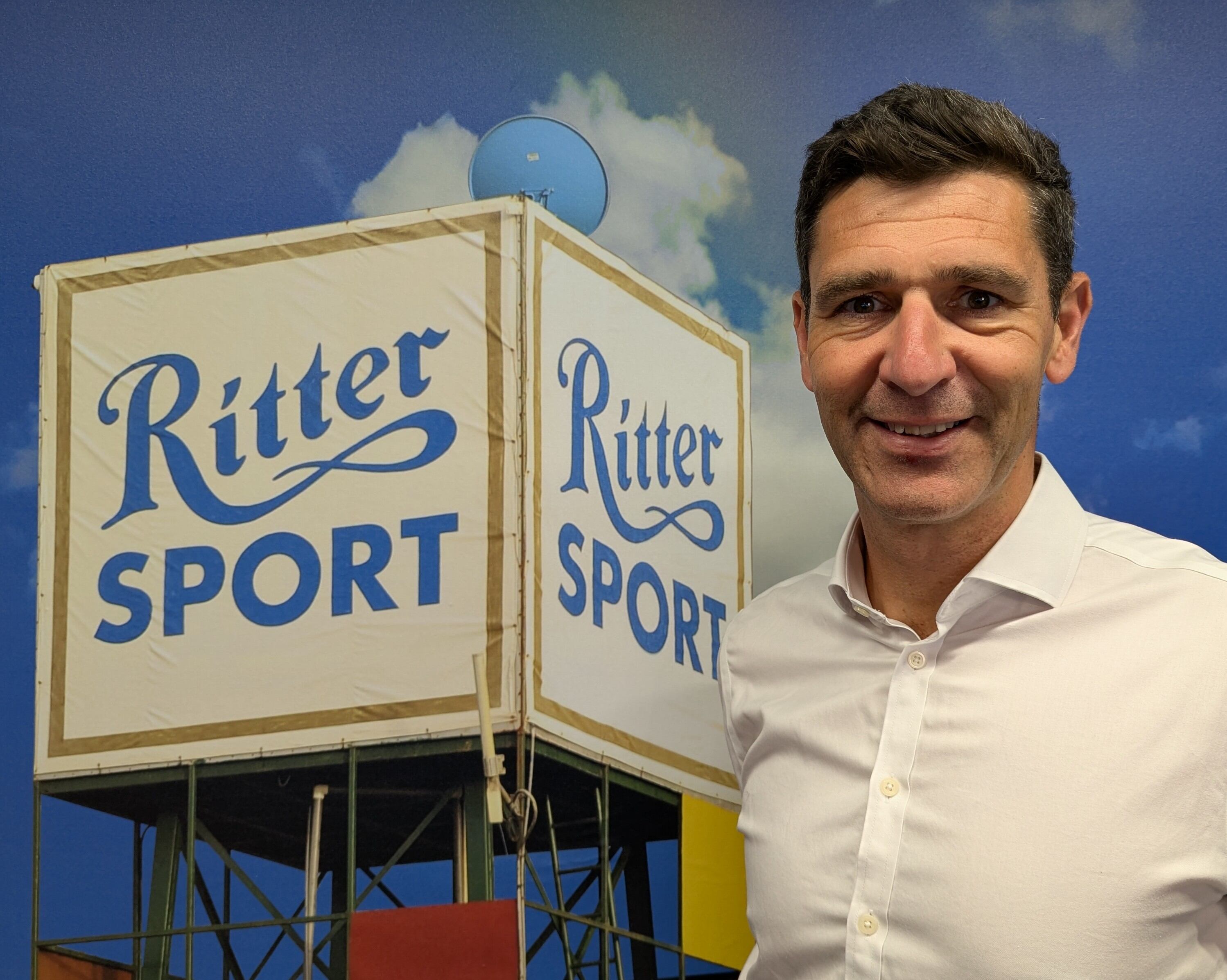 A corporate headshot of a man with brand asset